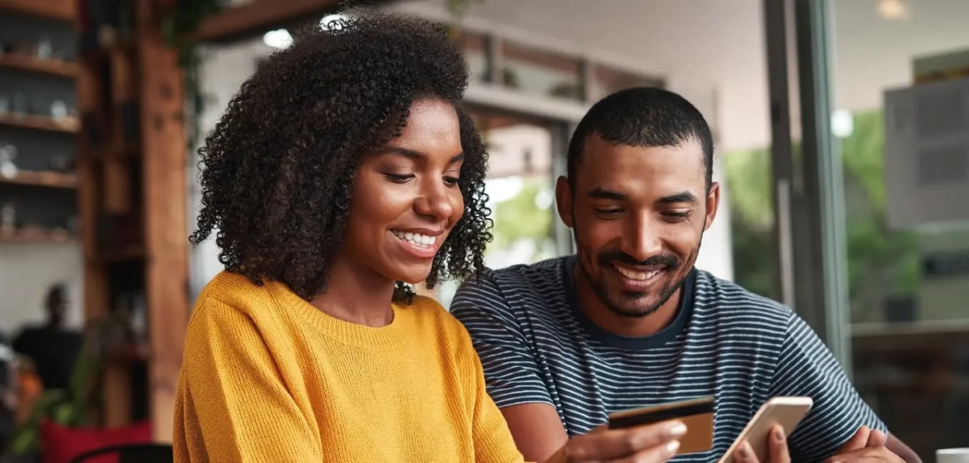 a man and woman making a purchase on a phone