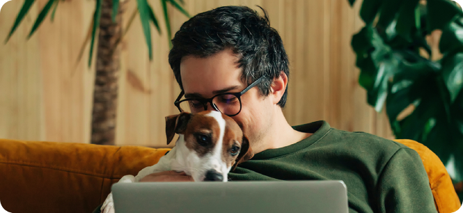 man hugging dog on laptop